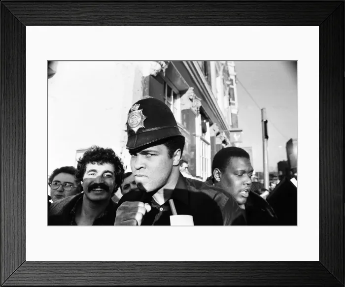 Framed Print : Muhammad Ali seen here on a visit to the UK poses wearing a policemans helmet Framed Print : Muhammad Ali seen here on a visit to the UK poses wearing a policemans helmet