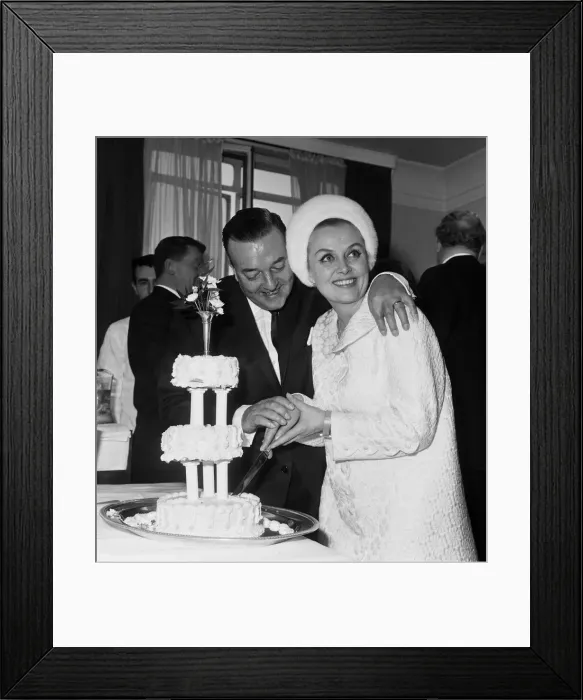 Framed Print : British musician Ronnie Ronalde cuts the cake with his new bride Yana after their wedding