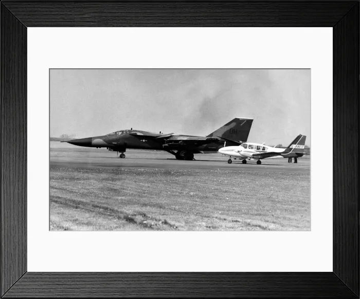 Framed Print : A USAF General Dynamics F-111 Aardvark sits on an airfield next to twin engined civil Framed Print : A USAF General Dynamics F-111 Aardvark sits on an airfield next to twin engined civil