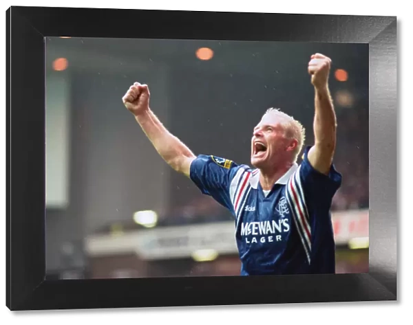 Rangers football player Paul Gascoigne, arms raised in joy after scoring a goal in their