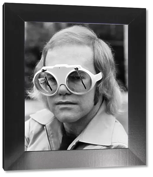 Pop singer Elton John at his home at Virginia Water. His glasses have window screen