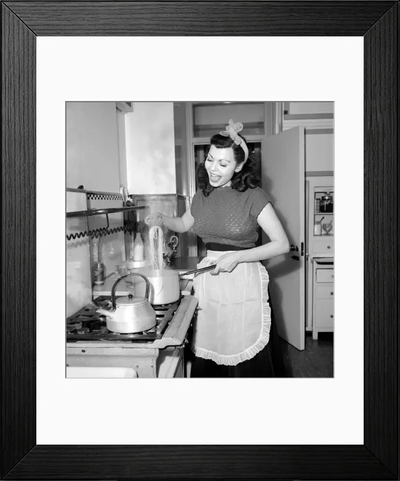 Framed Print : A Housewife cooking spaghetti in the kitchen, 1957 Framed Print : A Housewife cooking spaghetti in the kitchen, 1957