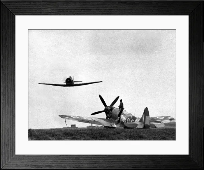Framed Print : A North American Harvard dual control training aircraft passes over a Supermarine Framed Print : A North American Harvard dual control training aircraft passes over a Supermarine