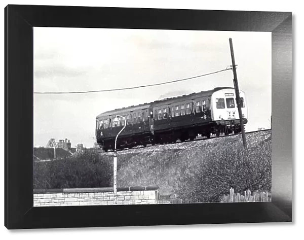 A British Rail diesel train roars along the track near Tyne Dock Station