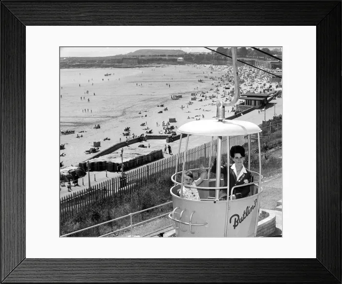 Framed Print : 13 June 1967 A redcoat and a camper enjoy a ride in the Butlins rope railway high above Framed Print : 13 June 1967 A redcoat and a camper enjoy a ride in the Butlins rope railway high above