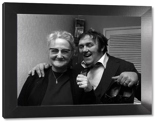 Les Dawson comedian 1974 arm round old woman holding shoes tie undone