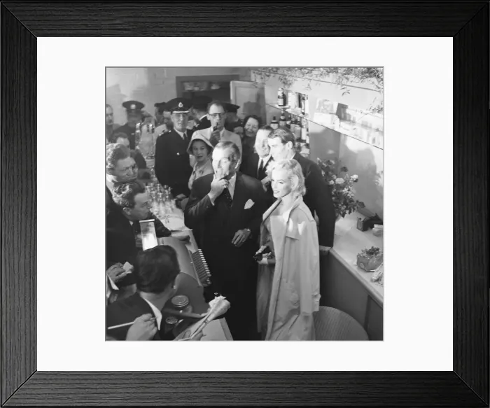 Framed Print : American actress Marilyn Monroe and Sir Laurence Olivier seek refuge from the waiting
