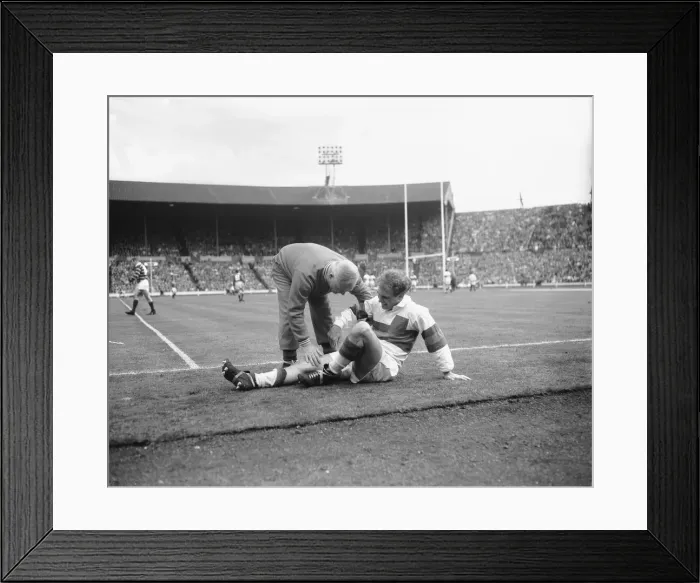 Framed Print : Hirst of Wakefield Trinity seen here gets treatment for a injury leg during the Rugby