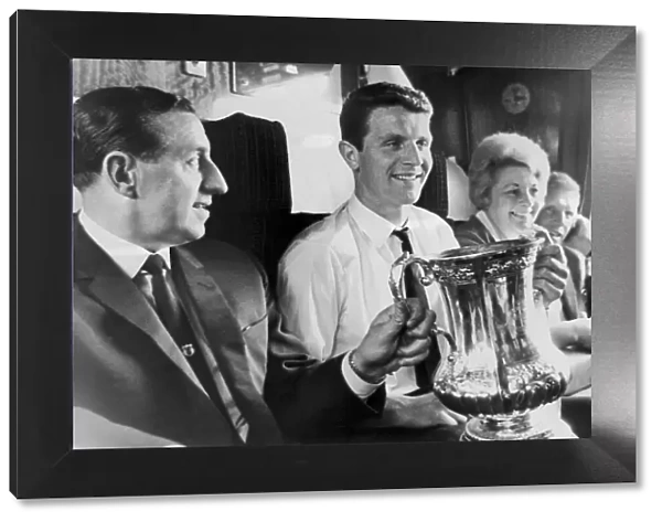 Everton manager Harry Catterick holds the FA Cup trophy on the train journey back to
