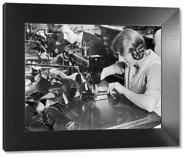 A woman machinist seen here of the factory floor of J Searsy of Northampton sewing uppers