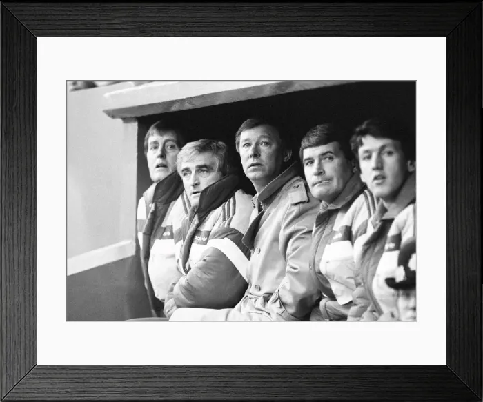 Framed Print : Manchester United manager Alex Ferguson sits in the dugout with coaching staff during Framed Print : Manchester United manager Alex Ferguson sits in the dugout with coaching staff during