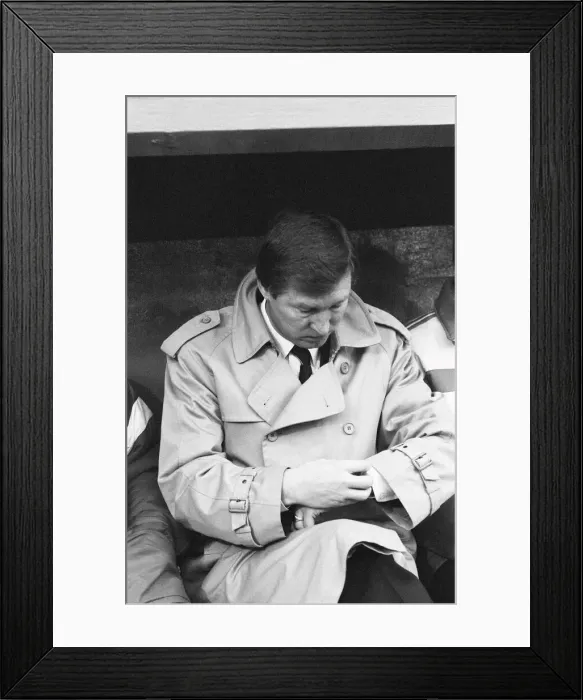 Framed Print : Manchester United manager Alex Ferguson checks his watch in the dugout during the League
