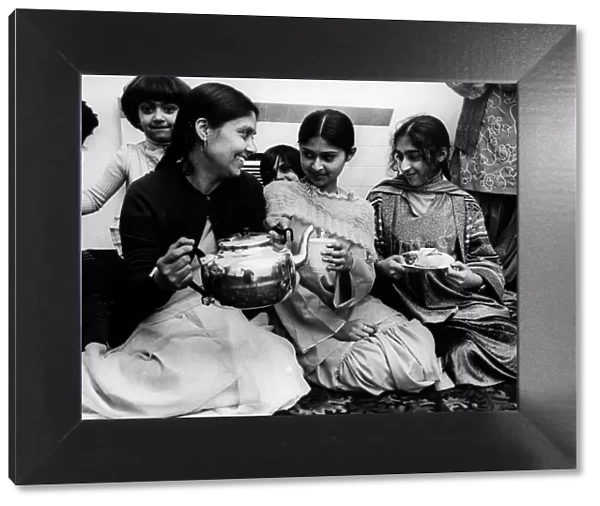 Some tea and cakes in the English style are served to a group of Pakistani women at