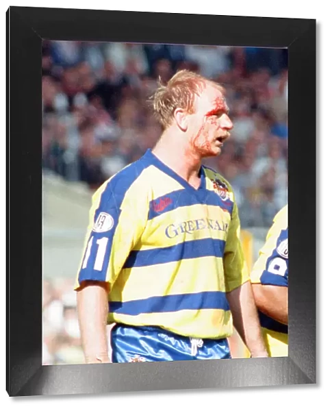 Bloodied Bob Jackson of Warrington is dejected after their defeat by Wigan in the Rugby