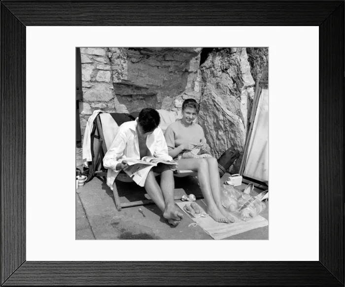 Framed Print : Hubby sitting in his unbuttoned shirt, bare legs and feet, dozes over a magazine