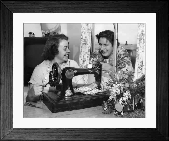 Framed Print : Busy at her sewing machine is Mrs. Beaty Evans, her next door neighbour, Mrs Framed Print : Busy at her sewing machine is Mrs. Beaty Evans, her next door neighbour, Mrs
