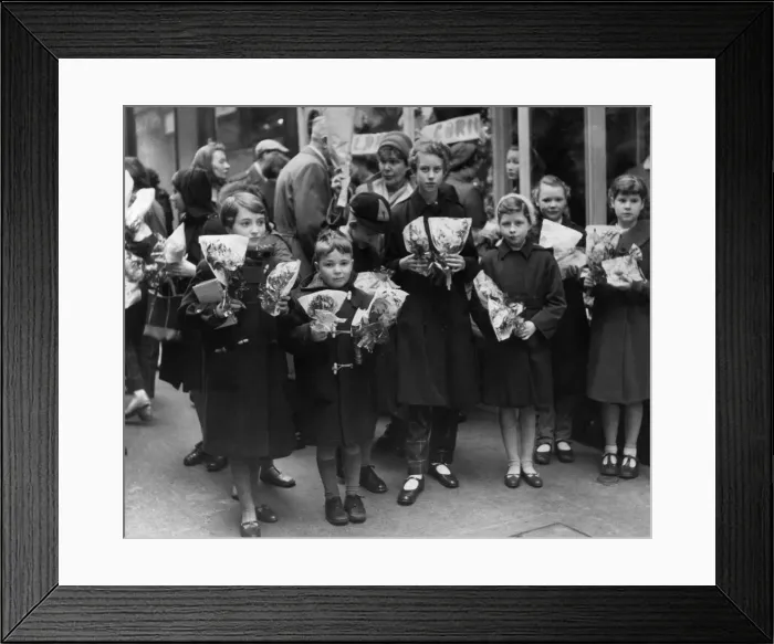 Framed Print : Children crowd outside a florists after buying thier flower for Mothering Sunday