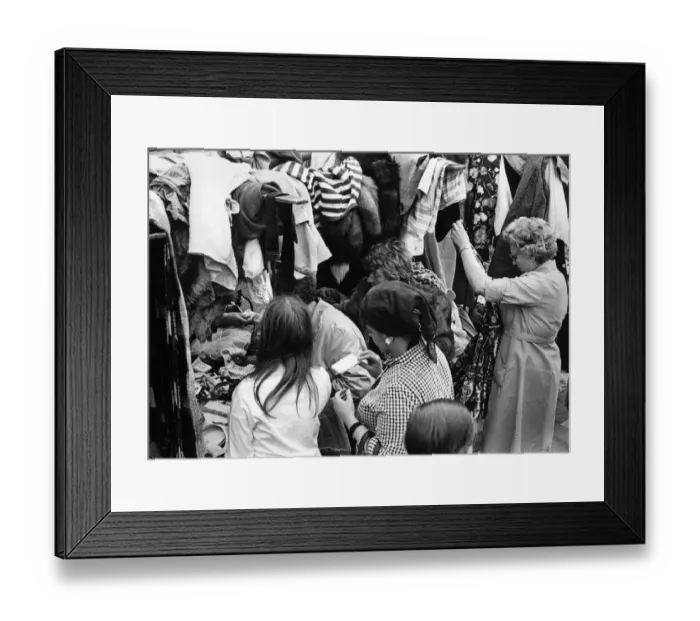 Framed Print : Eager shoppers rumage around one of the clothing stall in London