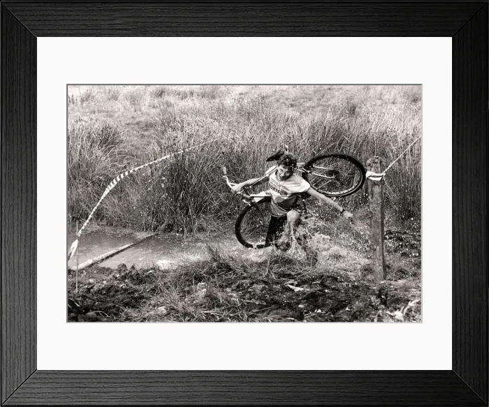 Framed Print : Mind how you go... a competitor carries his cycle across one of the many bogs negotiated