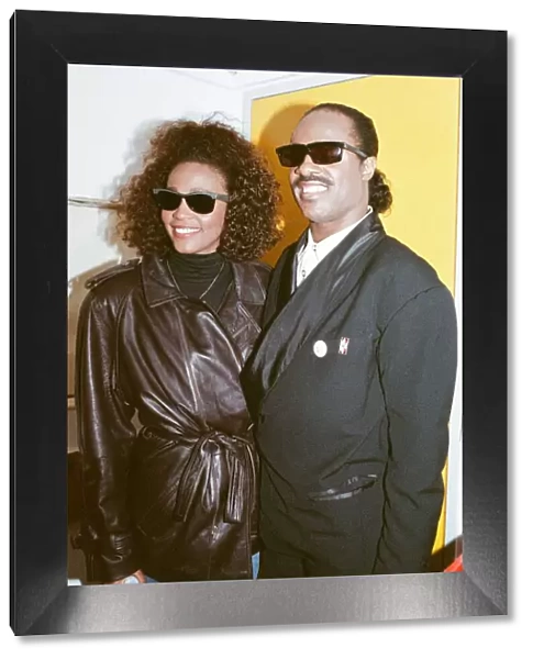 Whitney Houston and Stevie Wonder smile for a photograph backstage at the Nelson Mandela