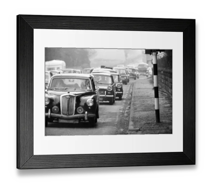 Framed Print : A view from the pavement as traffic is built up along the A556 towards Manchester