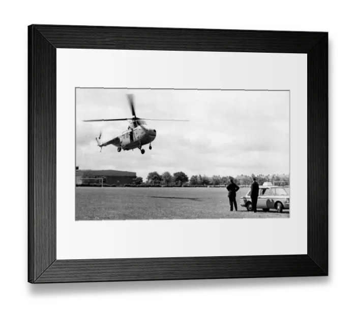 Framed Print : A RAF Westland Whirlwind search and rescue helicopter lands on a sportsfield next to two Framed Print : A RAF Westland Whirlwind search and rescue helicopter lands on a sportsfield next to two