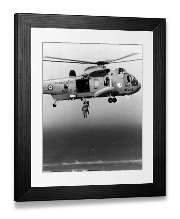 Framed Print : A RAF search and rescue Sea King from RAF Boulmer winches a man onboard plucking him out