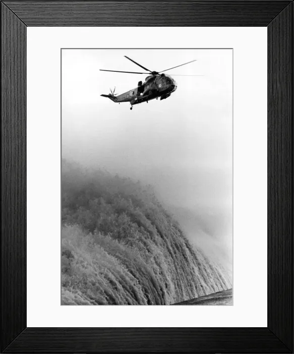 Framed Print : A RAF search and rescue Sea King helicopter from RAF Boulmer hovers above huge waves
