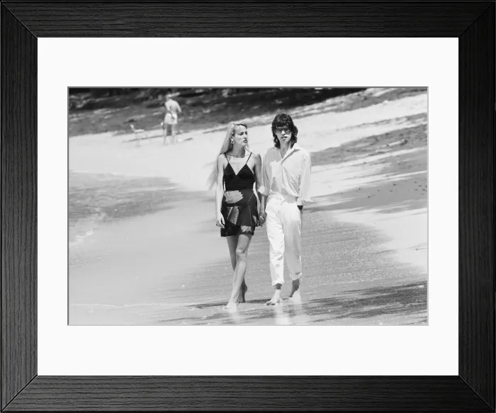 Framed Print : Mick Jagger and Jerry Hall seen here taking a stroll along the beach at Gibbs Bay in Framed Print : Mick Jagger and Jerry Hall seen here taking a stroll along the beach at Gibbs Bay in
