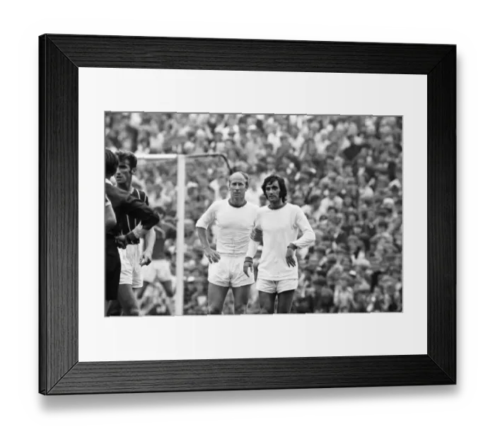 Framed Print : Manchester United footballers Bobby Charlton and George Best await a free kick during Framed Print : Manchester United footballers Bobby Charlton and George Best await a free kick during