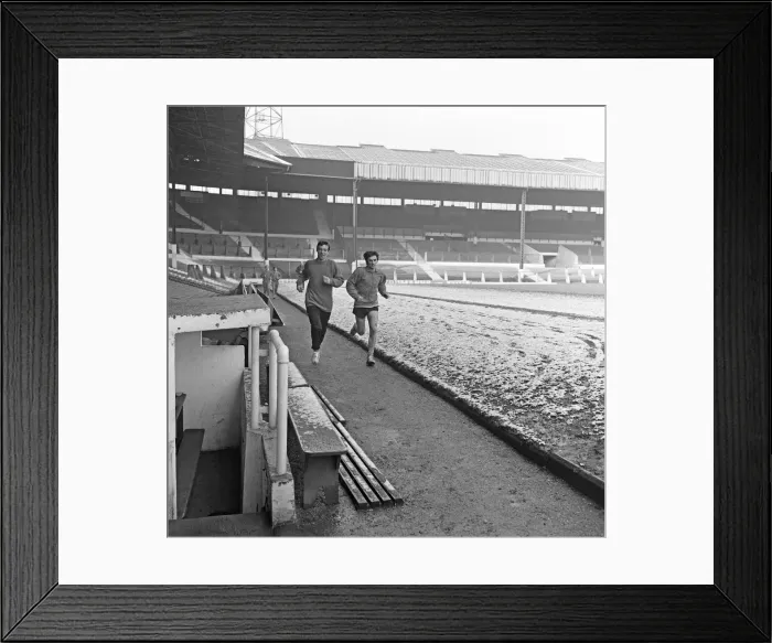 Framed Print : Manchester United footballer George Best running around a snow covered pitch at Old