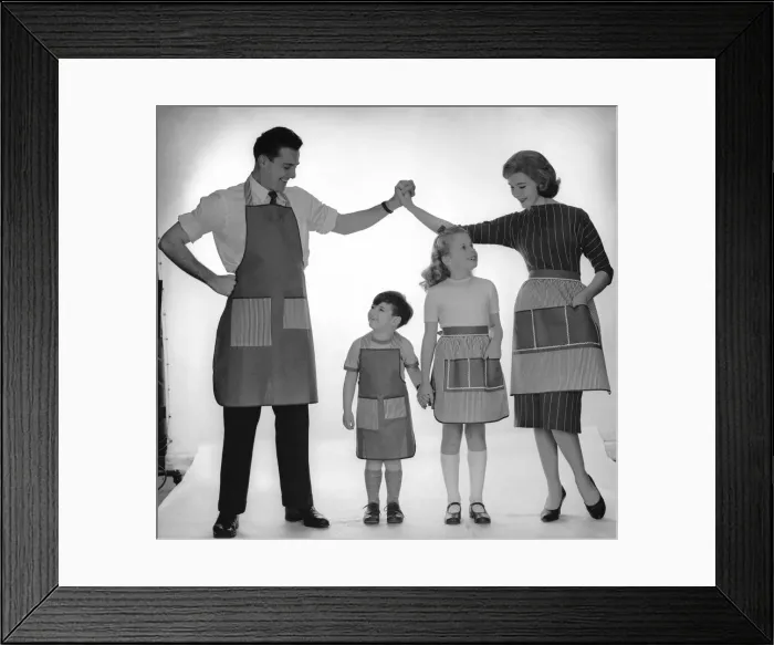 Framed Print : Family modelling a set of aprons for Reveille. 2nd December 1957 Framed Print : Family modelling a set of aprons for Reveille. 2nd December 1957