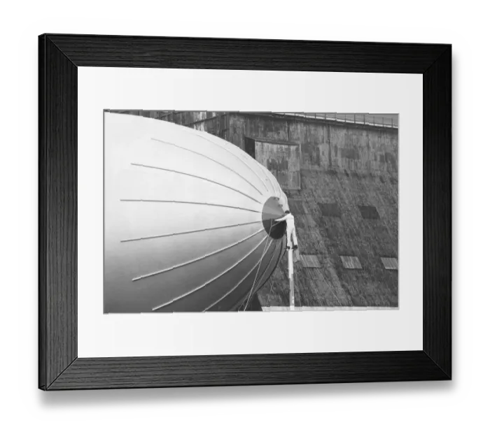 Framed Print : One of the ground crew prepares to detach the Goodyear airship Europa from her mooring