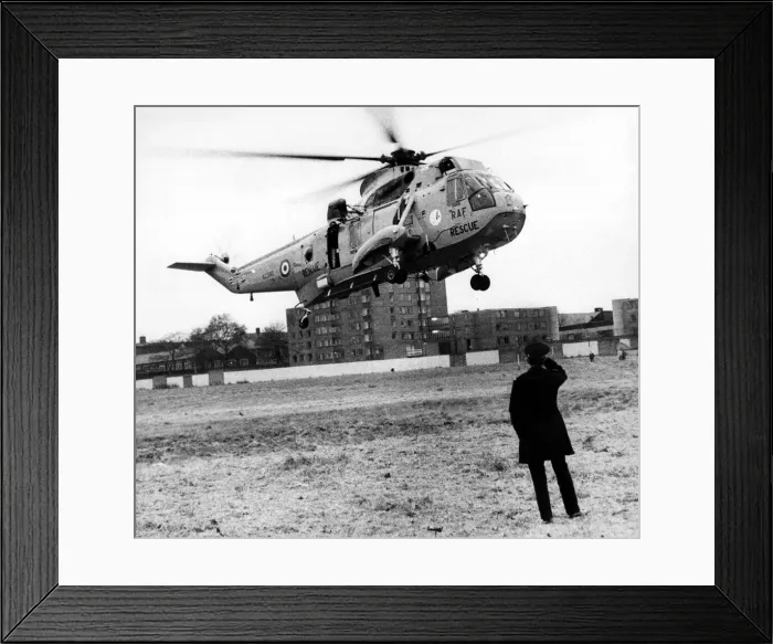 Framed Print : A policeman looks on as a RAF search and rescue Sea King helicopter from RAF Boulmer Framed Print : A policeman looks on as a RAF search and rescue Sea King helicopter from RAF Boulmer