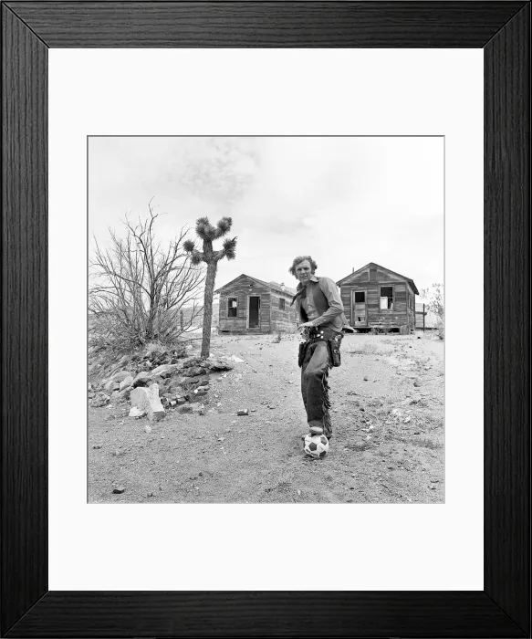 Framed Print : Bobby Moore poses for the camera dressed as Cowboy when the West Ham team were on a close
