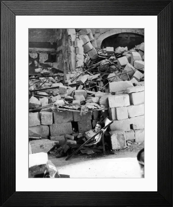 Framed Print : A young Maltese boy making himself as comfortable as possible by the ruins of his home