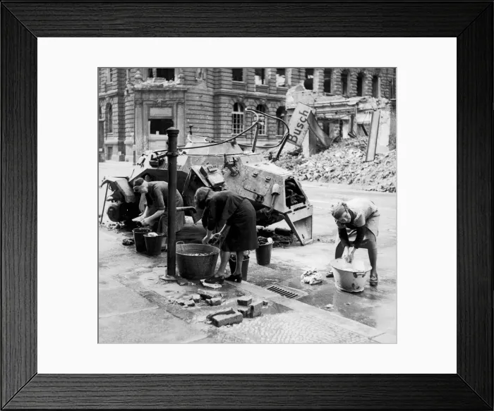 Framed Print : German women doing their washing in cold water in a street beside a knocked out German