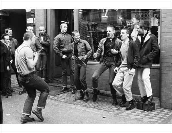 Teenage Skinheads dancing the Moonstomp outside a shop in London. 29th March 1980