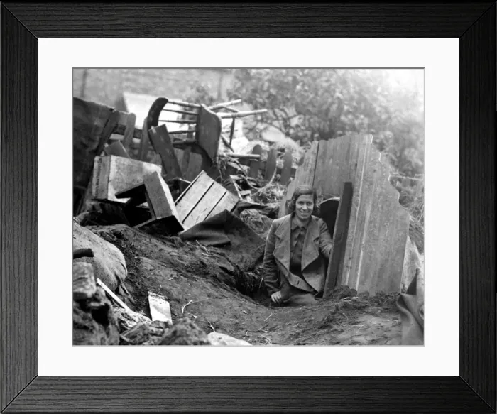 Framed Print : A young lady emerges from an Anderson Shelter after an air raid Framed Print : A young lady emerges from an Anderson Shelter after an air raid