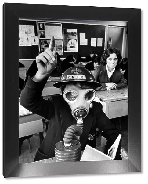 A schoolboy wears a gas mask and helmet during a lesson about World War Two