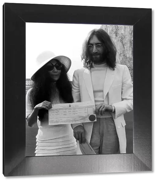 Beatles singer John Lennon and his new bride Yoko Ono holding their marriage certificate
