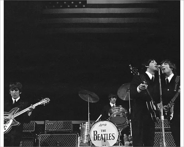 The Beatles onstage before the stars and stripes on the second night of their US tour at