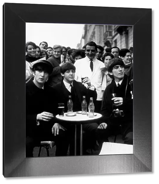 3 Beatles - John, Paul and George enjoy a glass of coca cola at a street cafe in Paris