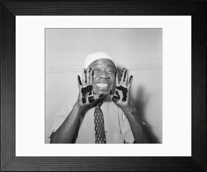 Framed Print : Louis Armstrong, veteran Jazz star, dips his hands in black ink