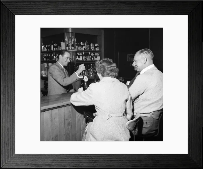 Framed Print : Former Middlesbrough footballer Wilf Mannion serving customers at the bar in his pub