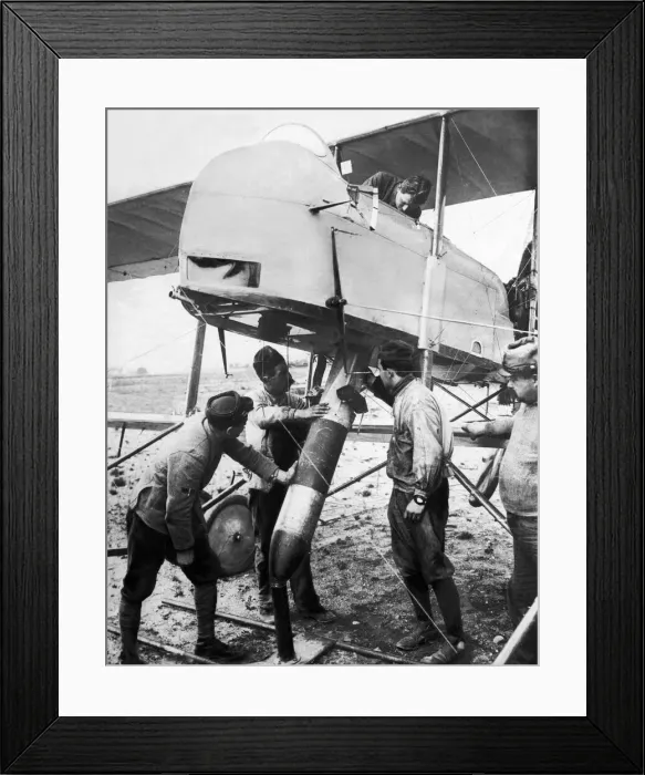 Framed Print : Ground crew fit the tail vanes and manoeuvre a bomb into the bomb bay of a French Air