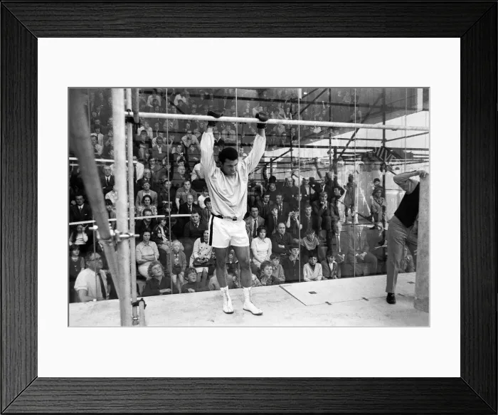 Framed Print : Muhammad Ali in a cage protected by glass from hundreds of fans who paid 50p to watch him