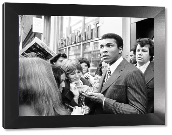 Muhammad Ali signing autographs ahead of his rematch with Joe Frazier. January 1974