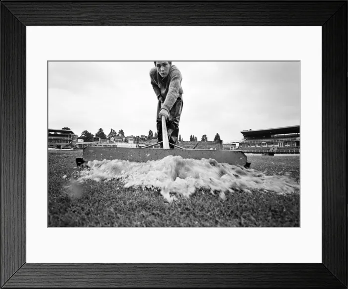 Framed Print : Groundsman Ian Guys tries to clear the water from the pitch at Edgbaston ahead of Framed Print : Groundsman Ian Guys tries to clear the water from the pitch at Edgbaston ahead of
