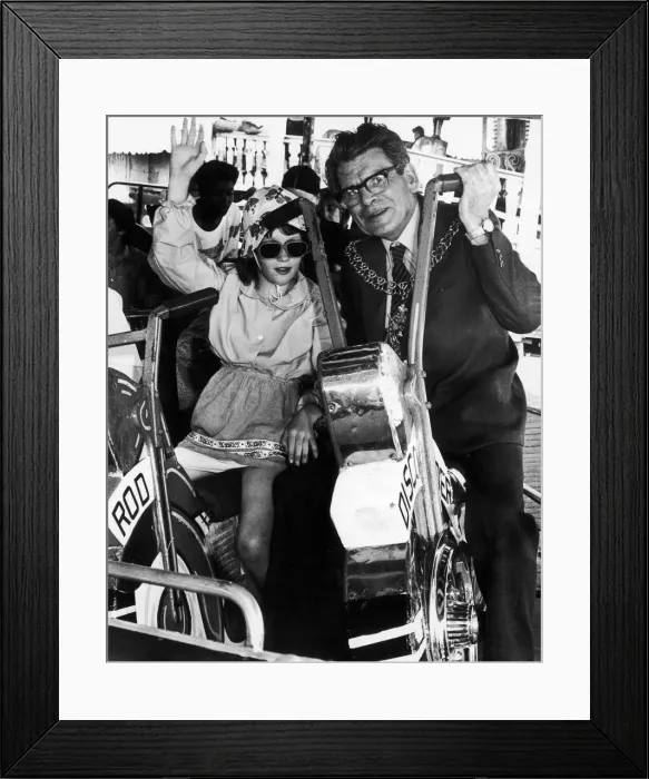 Framed Print : Councillor Weaver with one of the youngsters from Wisteria Lodge on the merry-go-round